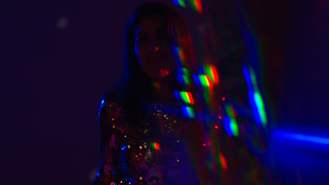 Close-Up-Of-Woman-Having-Fun-Dancing-In-Disco-Nightclub-Or-Bar-Shot-With-Tinsel-in-Foreground-1